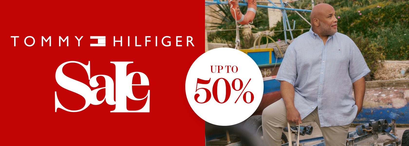 Tommy Hilfiger sale up to 50% off with a man in a light blue shirt and beige pants.