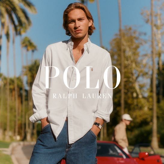 Ein Mann mit langen Haaren trägt ein weißes Polo Ralph Lauren Hemd und Jeans. Im Hintergrund Palmen und ein rotes Auto.