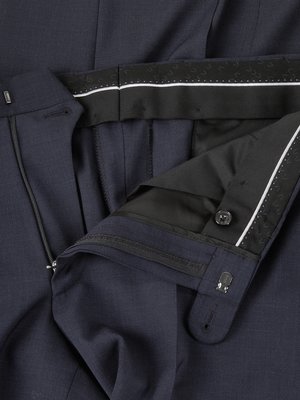 Close-up of navy blue suit trousers, showing interior waistband detail, zipper, and button.  The fabric has a subtle texture.  A small brand marking is visible on the interior waistband.