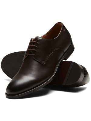 Braune Lederschuhe mit Schnürung, Derby-Stil.  Ein Schuh liegt auf der Seite, der andere darauf.  Die Schuhe wirken elegant und hochwertig.