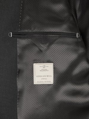 Close-up of dark gray suit jacket interior lining showing a pocket and a fabric label. The label reads "Officina Valdagno," "Super 120's Wool Stretch," and "Exclusively for Diesel."
