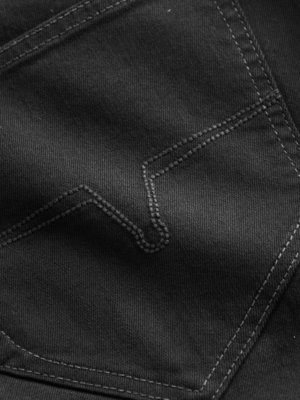 Close-up of a black fabric pocket with decorative stitching. The stitching forms a unique, slightly curved pattern on the pocket. The fabric appears to be a denim or similar material.