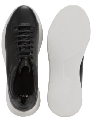 Overhead view of a pair of black leather BOSS sneakers with white soles.  The shoes are laced and feature the BOSS logo on the tongue and insole. One shoe is shown from the top and the other shows the sole.