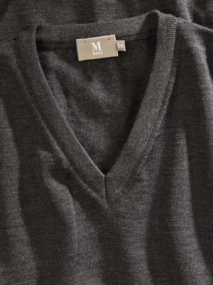 Close-up view of a dark gray, v-neck sweater. The neckline is prominently visible. A rectangular tag with the brand name "MARZ" and a size number "58" is sewn into the collar. The fabric appears knitted.