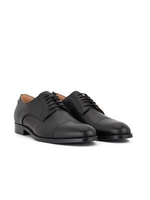 Two black leather oxford shoes are displayed on a white background. The shoes have laces, rounded toes, and low heels. One shoe is slightly in front of the other.