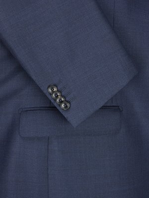 Close-up of a blue suit jacket. The image focuses on the left sleeve, showing four dark buttons and the edge of a pocket. The fabric has a subtle texture.