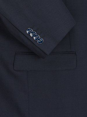 Nahaufnahme eines dunkelblauen Sakkos mit vier Knöpfen am Ärmel. Die Knöpfe sind rund und silberfarben umrandet. Der Ärmel hat eine aufgesetzte Pattentasche. Der Stoff hat eine feine Struktur.