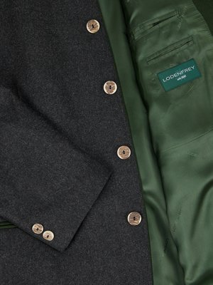 Close-up of a dark gray jacket with wooden buttons. The jacket's interior is lined with green satin and has a small pocket. A label that reads "Lodenfrey seit 1842" is visible inside.