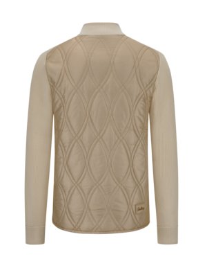 Back view of a beige jacket. The upper back is beige and quilted with a diamond pattern. The sleeves are cream-colored and ribbed. The collar is also cream-colored. A small tag is visible on the jacket.