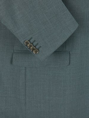 Naheinstellung eines Jacketts in Türkis mit vier Knöpfen am Ärmel. Auf der linken Seite befindet sich eine angedeutete Brusttasche. Der Stoff weist eine feine Struktur auf.