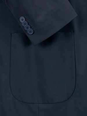 Close-up of a dark blue blazer. The left sleeve is visible, with four matching buttons aligned vertically. The breast pocket is outlined. The fabric appears smooth and the pocket is rounded at the bottom.