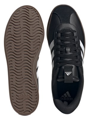 Zwei Ansichten eines schwarzen Sneakers, links die Sohle, braun mit Adidas-Logo, rechts von oben. Der Sneaker hat drei silberne Streifen an der Seite und weiße Schnürsenkel. Adidas-Logo auf der Zunge.