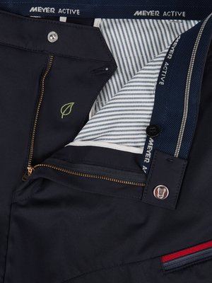 Close-up of dark blue pants, partially unzipped. The zipper is visible, as are the buttons and a leaf logo. The inside lining has a striped pattern. The brand name "MEYER ACTIVE" is visible on the waistband.
