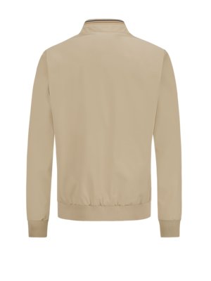 Rückansicht einer beigefarbenen Herrenjacke. Die Jacke hat einen Stehkragen mit dünnen Streifen. Die Ärmel sind lang und enden mit gerippten Bündchen. Der Saum ist ebenfalls gerippt.