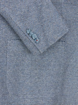 Nahaufnahme eines blauen Sakkos. Sichtbar sind der Ärmel, vier blaue Knöpfe und ein Teil der Knopfleiste. Der Stoff ist ein blau-weiß gemusterter Leinenstoff.