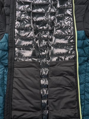 Nahaufnahme einer schwarzen und blaugrünen Steppjacke, teilweise geöffnet. Das Futter ist silberfarben glänzend und gepolstert, mit zwei schwarzen Taschen. Ein gelber Reißverschluss verläuft vertikal. Der Stoff ist aufgeteilt.