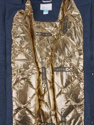Nahaufnahme der Innenseite einer dunkelblauen Jacke. Innenfutter in Gold mit Wabenmuster und Etiketten mit schwarzer Schrift. Ein Markenlogo ist am oberen Rand zu sehen. Die Jacke ist geöffnet.