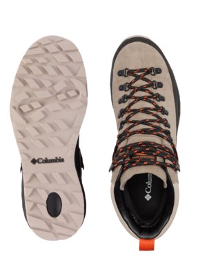 Two Columbia brand hiking boots displayed from a top-down perspective. One shows the patterned sole in tan, the other boot in beige suede with black and orange laces and a black collar.