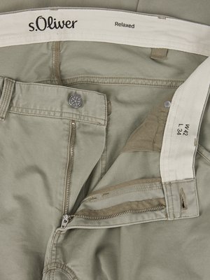 Close-up of khaki-colored pants laid flat. The zipper is partially unzipped. A button is visible on the waistband, with "s.Oliver" and "Relaxed" printed on the inner waistband.  Size label is visible: W42 L34.