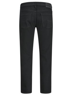 Back view of black denim jeans with two back pockets and a leather brand patch on the waistband.