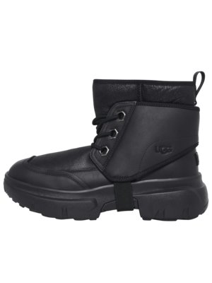 A black UGG winter boot. The boot has a thick sole, a padded collar, and laces with metal eyelets. A strap encircles the boot just below the ankle. The UGG logo is visible on the side of the boot.