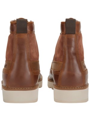 Two brown leather boots are shown side by side, seen from the back. Each boot has a suede panel at the back, a leather heel, and a thick, off-white sole. The boots have a pull tab at the top.