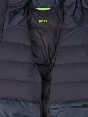 Granatowa kurtka z pikowanym wypełnieniem i widoczną wszywką z logo BOSS w neonowym kolorze.