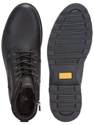 Ein schwarzer Lederstiefel, der von oben und die Sohle von unten gezeigt wird. Der Stiefel hat Schnürsenkel und einen Reißverschluss. Die Sohle ist schwarz mit Profil und einem gelben rechteckigen Label.