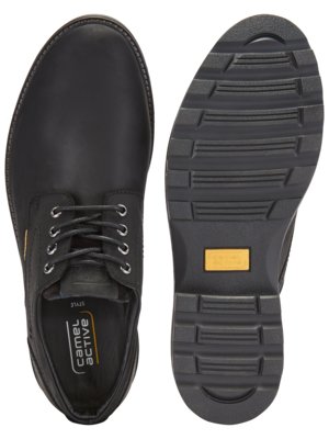Zwei schwarze Lederschuhe, Ansicht von oben und von der Sohle. Der linke Schuh hat Schnürsenkel, der rechte zeigt eine profilierte Sohle. Auf der Einlegesohle steht "camel active".