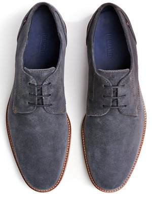 Draufsicht auf zwei graue Schnürschuhe aus Wildleder, die auf einer weißen Oberfläche liegen. Die Schuhe haben eine braune Sohle. Innen sind die Schuhe blau mit dem Schriftzug "Lloyd".