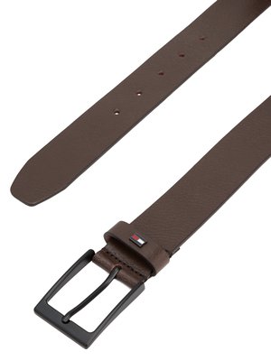 Brauner Ledergürtel mit schwarzer Schnalle, das Band ist an der linken Seite, oben links ist das Leder breit, die Schnalle ist fast senkrecht, ein kleines Logo ist am Gürtel.