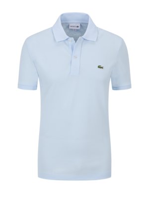 Een lichtblauwe Lacoste polo shirt. Het shirt heeft een kraag, korte mouwen en drie knopen. Een klein groen krokodillenlogo is op de borst. De achtergrond is wit.