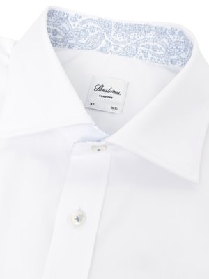 Close-up of a white dress shirt with a blue paisley pattern on the inside of the collar and a Stensströms label.