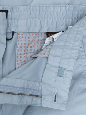 Close up of light blue fabric with an orange BOSS logo pattern lining visible inside a pocket.