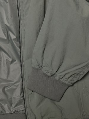 Graues Jackenfutter mit Reißverschluss und geripptem Ärmelbündchen im Detail