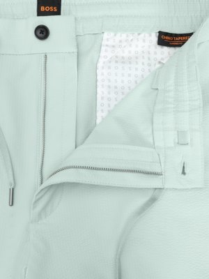 Jasne, oto propozycja tekstu ALT:Jasne spodnie chino z widocznym zamkiem, guzikiem i metką "BOSS CHINO TAPERED FIT".