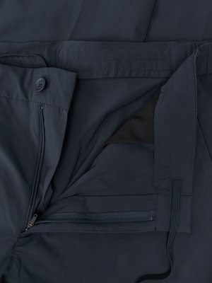 Nahaufnahme der geöffneten Reißverschlussöffnung einer dunkelblauen Hose mit einem Knopf und einem Kordelzug.