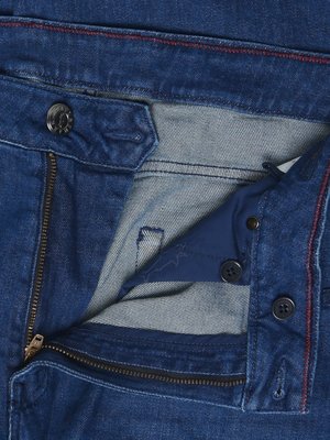 Naheinstellung einer geöffneten Jeans mit Reißverschluss, Knöpfen und roten Ziernähten.