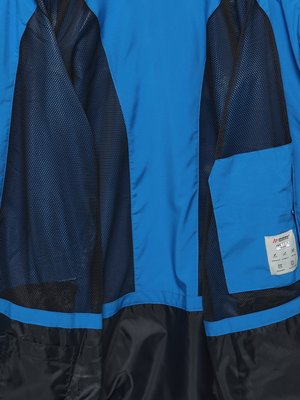 Close-up view of the interior of a blue jacket with navy mesh lining and a pocket on the right side.