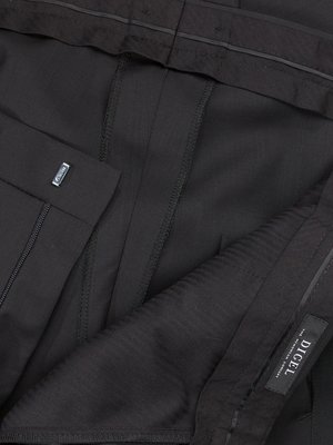 Close-up of black dress pants. The pants are folded, showing details of the stitching, pleats, and a metal tag. The label "DIGEL" is visible. The fabric appears to have a subtle texture.