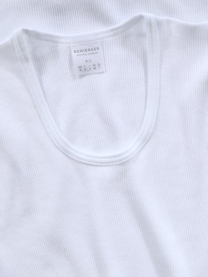 Close-up of a white ribbed undershirt. The shirt has a scoop neck and a small tag on the inside collar with the brand name "Schießer". The fabric is white and appears to be a ribbed cotton material.