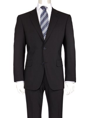 Ein schwarzer Anzug, bestehend aus einer Jacke mit zwei Knöpfen, einer passenden Hose und einem weißen Hemd mit gestreifter Krawatte. Die Kleidung wird auf einer Schaufensterpuppe präsentiert.