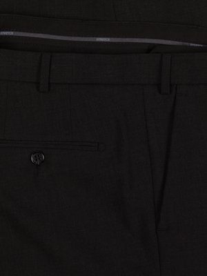 Nahaufnahme einer schwarzen Hose mit einem Knopf, einer Gesäßtasche und Gürtelschlaufen. Der Bund zeigt das Wort "STRETCH". Die Hose ist aus einem fein strukturierten Stoff gefertigt.