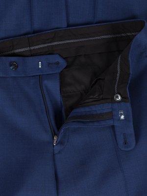 Detailní záběr na modré kalhoty. Je vidět rozepnutý zip, zapínání na knoflík a poutko s dírkou. Vnitřek kalhot je černý. Černý lem s šedým proužkem.