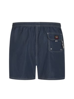 Swimming trunks with logo patch