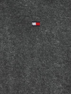 Grauer Textilgrund mit einem kleinen, rechteckigen Logo in den Farben Weiß, Rot und Blau. Die Textur des Stoffes ist deutlich erkennbar.