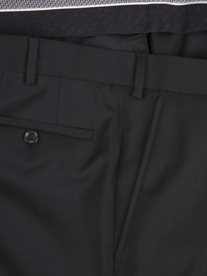 Close-up view of black dress pants. Visible details include the waistband with belt loops, a buttoned pocket, and a portion of a side pocket. The fabric appears smooth.
