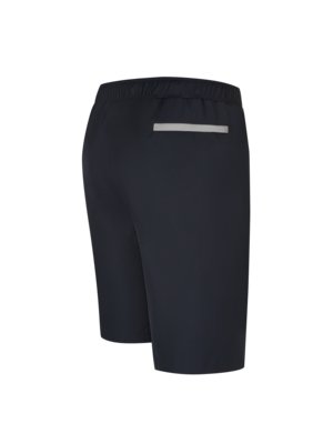 A close-up, three-quarter view of black athletic shorts is shown. The shorts have an elastic waistband and a small, rectangular, reflective silver detail on the back. The shorts are wrinkle-free.