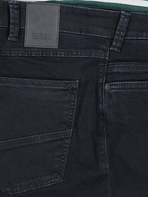 Nahaufnahme der Rückseite einer schwarzen Jeanshose. Sichtbar sind eine Gesäßtasche, eine rechte Gesäßtasche, die Naht, ein Lederetikett mit dem Markennamen EUREX und der Hosenbund.