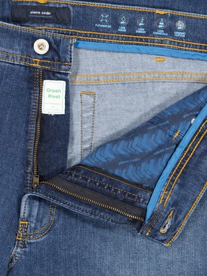 Džíny s rozepnutým zipem. Značka Pierre Cardin. Detail rozparku s vnitřní látkou s modrým vzorem. Malá visačka "Green Rivet". Na pasu ikony s textem FUTUREFLEX, LESS WATER, LESS ENERGY, LESS CHEMICALS a ORGANIC COTTON.